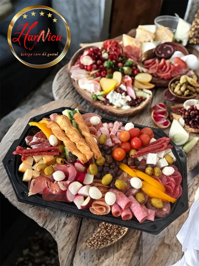 Platou de charcuterie pe tocator rustic de lemn, langa sigla Harnicu