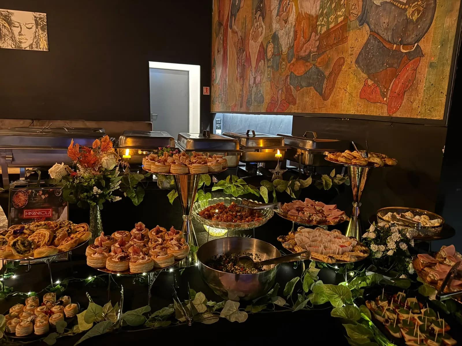 Etajere cu aperitive si verdeata, intr-o sala decorata pentru un eveniment de seara